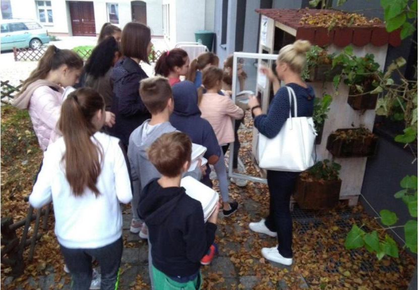 a line of people by a fridge in the street